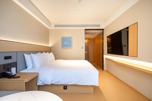A modern hotel room with a large bed, a bedside table with a phone, and a flat-screen TV mounted on the wall. - Ji Hotel Guangzhou Sun Yat-sen University Metro (Guangzhou)