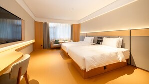 Une chambre d’hôtel moderne avec deux lits, un bureau et une chaise.