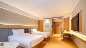 Une chambre d’hôtel avec deux lits, un bureau, une chaise et un grand miroir.