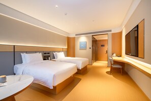 A hotel room with two beds, a desk, a chair, and a large mirror. - Ji Hotel Guangzhou Sun Yat-sen University Metro (Guangzhou)