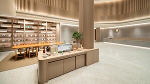Un intérieur moderne comprenant un comptoir d’accueil, un espace détente et des étagères à livres.