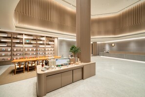 A modern interior with a reception desk, seating area, and bookshelves. - Ji Hotel Guangzhou Sun Yat-sen University Metro (Guangzhou)