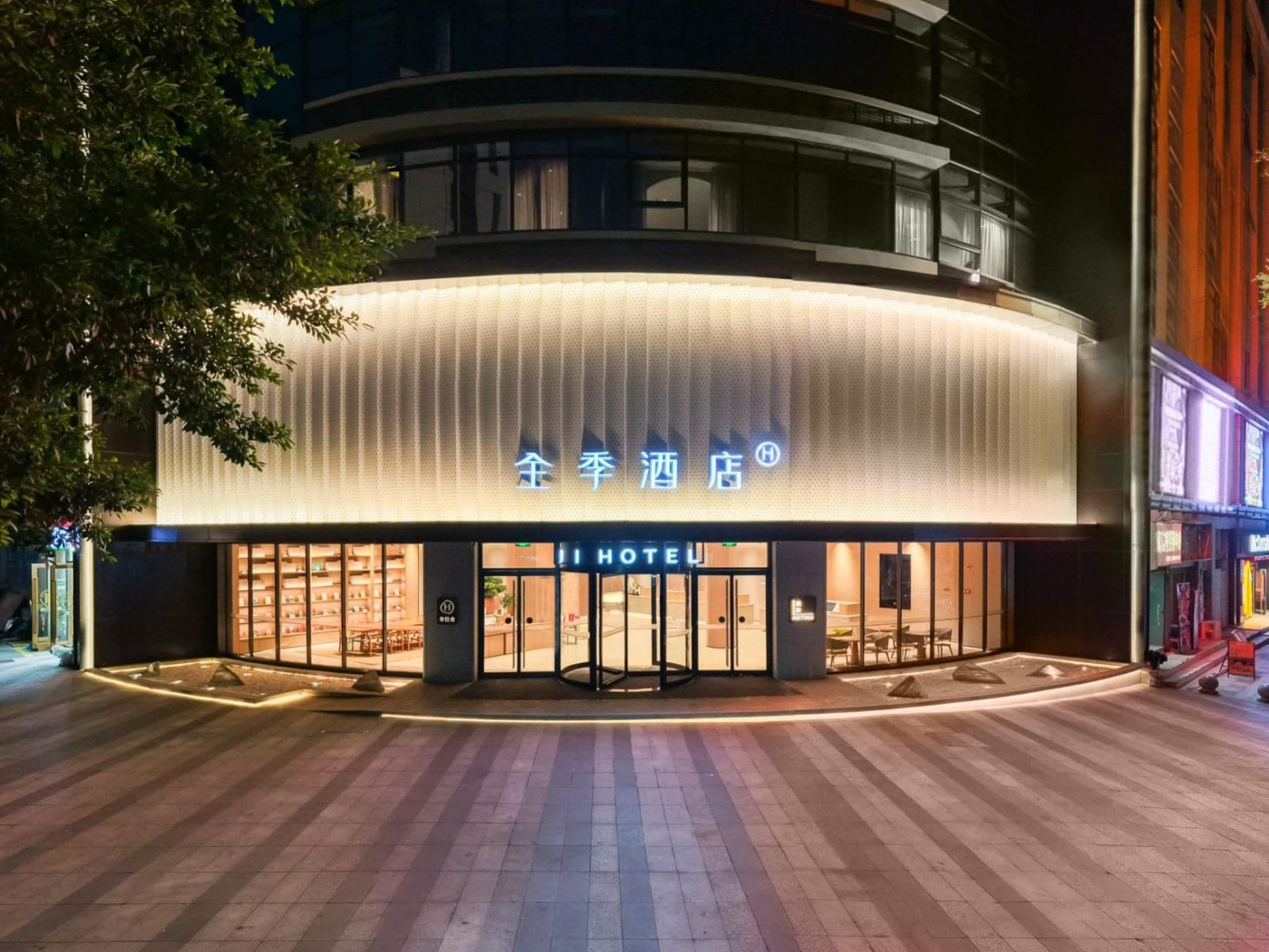Un hotel de diseño moderno, con una entrada destacada y un letrero con caracteres chinos.