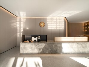 Un baño moderno con encimera de mármol, lavabo integrado y una bañera grande.