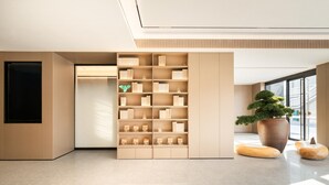 A modern interior with a large bookshelf, a potted plant, and a minimalist design. - Ji Hotel Guangzhou Baiyun Tinggang Metro Station (Guangzhou)