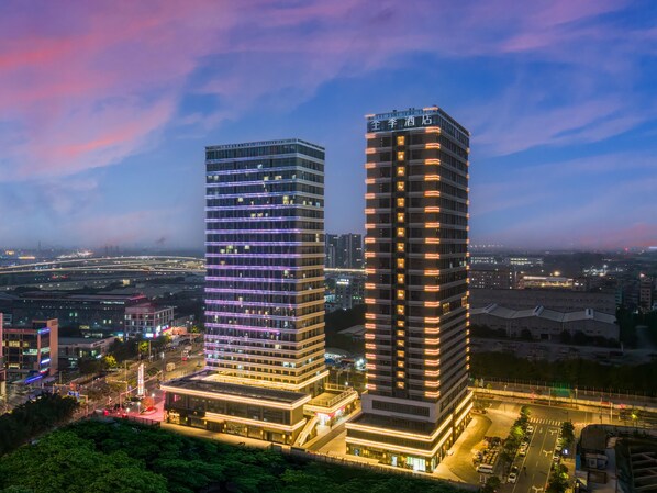 Two high-rise buildings with modern architecture, featuring illuminated windows and a flat facade.
