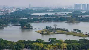 A large park with multiple lakes, walking paths, and a bridge. - Ji Hotel Guangzhou Baiyun Tinggang Metro Station (Guangzhou)