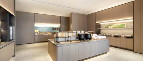 Una cocina moderna con una isla central, electrodomésticos integrados y un diseño limpio y minimalista.