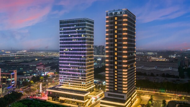 Two high-rise buildings with modern architecture, featuring illuminated windows and a flat facade. - Ji Hotel Guangzhou Baiyun Tinggang Metro Station (Guangzhou)