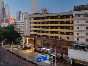 A multi-story hotel with a modern facade, multiple balconies, and a prominent entrance with illuminated signage. - Ji Hotel Guangzhou Modiesha Metro Station (Guangzhou)