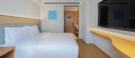 A hotel room with a large bed, a wooden nightstand, a TV, and a wooden counter.