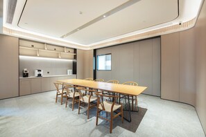 A modern conference room with a long table, chairs, a coffee machine, and a large window. - Ji Hotel Guangzhou Modiesha Metro Station (Guangzhou)