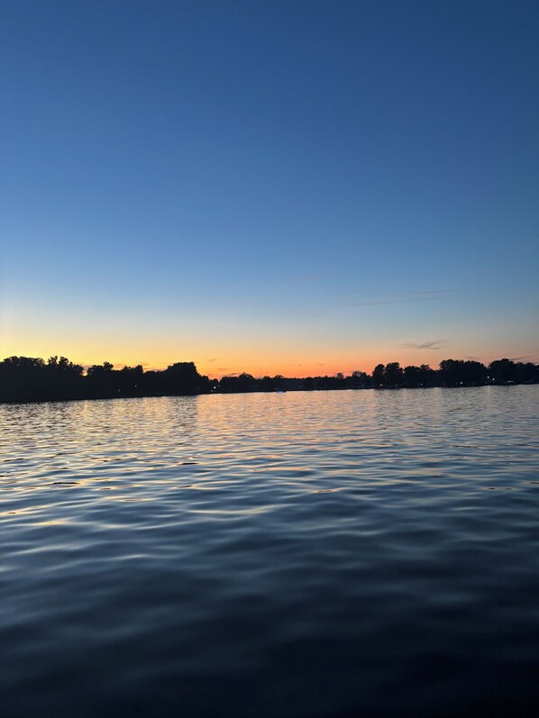 Un lago tranquilo al atardecer bajo un cielo despejado.