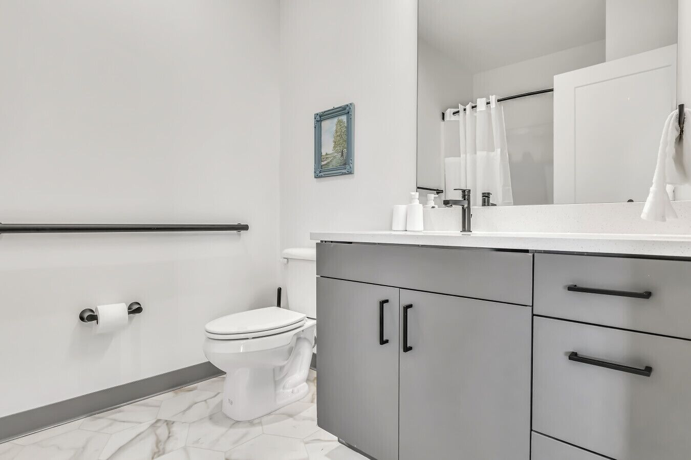 Un baño moderno con inodoro, lavabo con espejo y mueble.