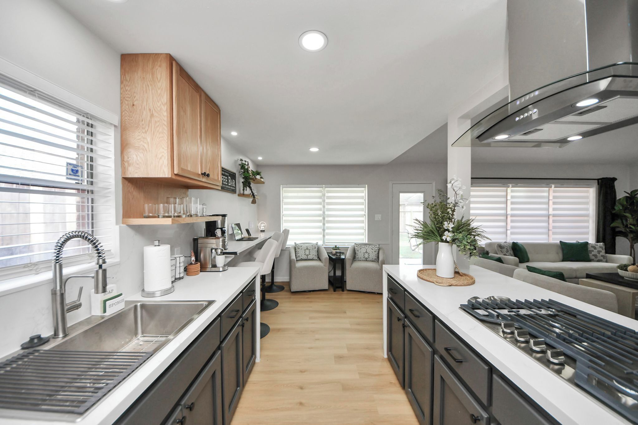A modern kitchen with a central island, built-in appliances, and a dining area with a sofa and chairs.