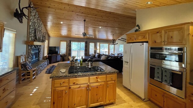 A spacious kitchen with wooden cabinets, a granite countertop, and stainless steel appliances.