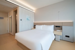 A modern hotel room with a large bed, bedside tables, a wardrobe, and a wall-mounted TV. - Ji Hotel Guangzhou Huangpu East Metro Station (Guangzhou)