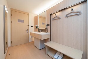Une salle de bain moderne avec un meuble-lavabo en bois, un miroir et un banc.