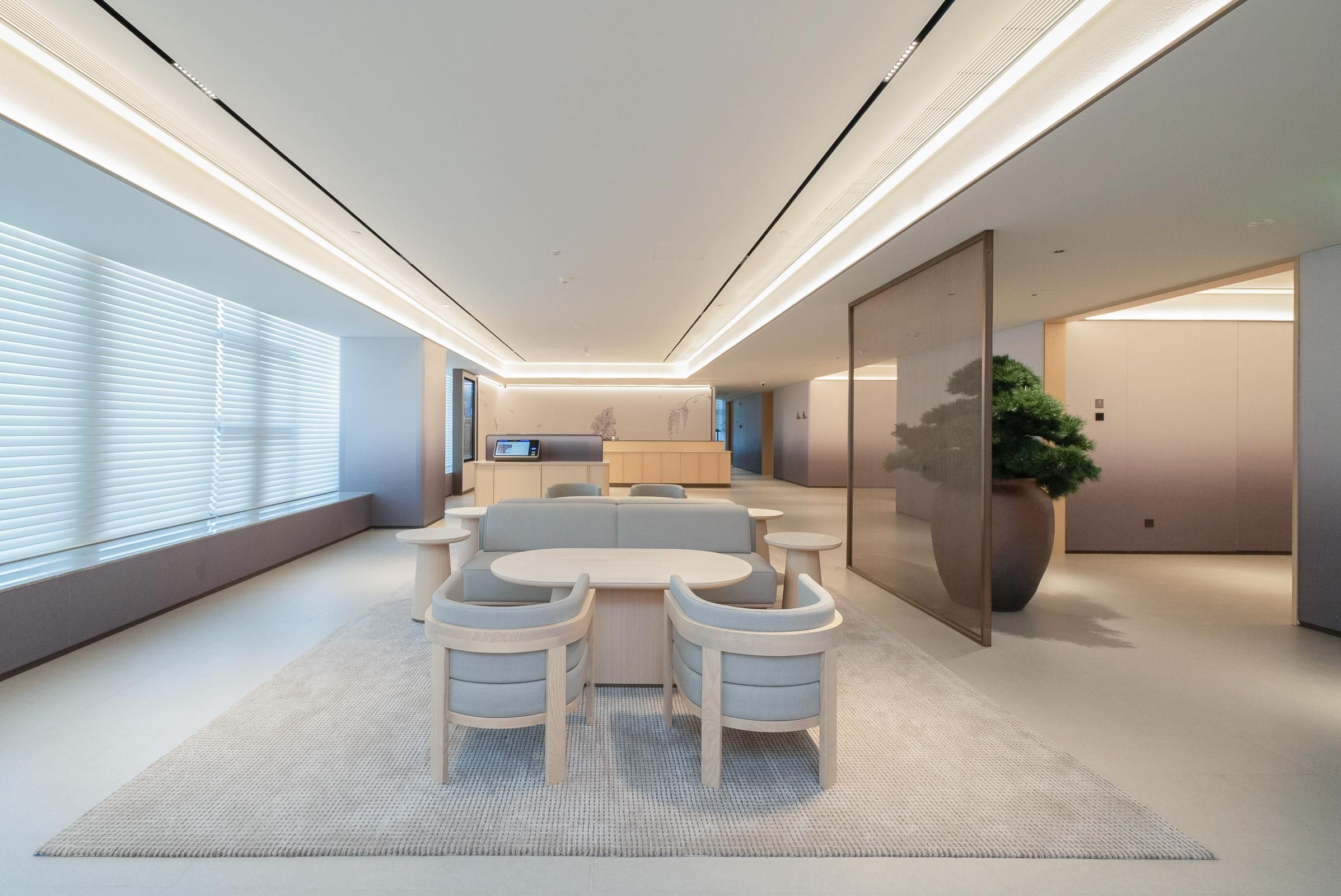 Un interior moderno con un conjunto de sofás, una mesa de comedor y una gran planta en maceta.
