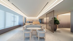 A modern interior with a sofa set, a dining table, and a large potted plant. - Ji Hotel Guangzhou Huangpu East Metro Station (Guangzhou)