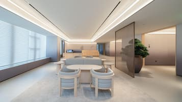 Un interior moderno con un conjunto de sofás, una mesa de comedor y una gran planta en maceta.
