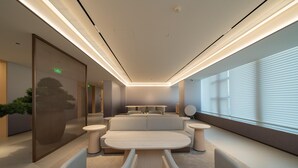 A modern, well-lit lounge area with a sofa, round tables, and a large window with blinds. - Ji Hotel Guangzhou Huangpu East Metro Station (Guangzhou)