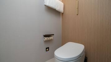 A modern bathroom with a toilet, a towel rack, and a toilet paper holder.