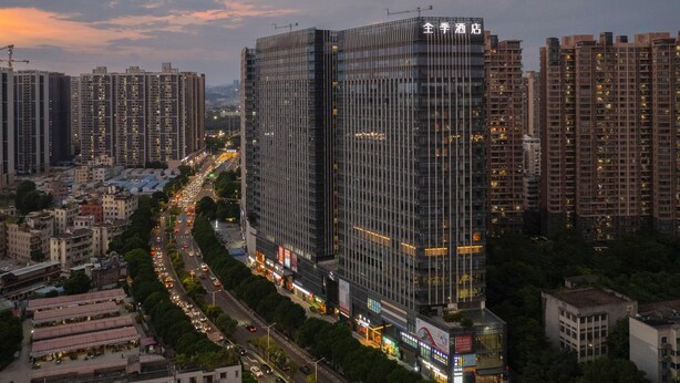A high-rise hotel with multiple floors, surrounded by other buildings and a busy street.