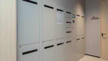 Una fila de casilleros con números, un aviso y un cartel que indica la sala de equipaje.