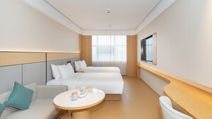 A hotel room with a bed, a sofa, a small table with cups, and a TV on the wall. - Ji Hotel Guangzhou Huangpu Wenchong (Guangzhou)