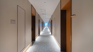 A long, narrow hallway with doors on both sides, leading to individual rooms. - Ji Hotel Guangzhou Huangpu Wenchong (Guangzhou)