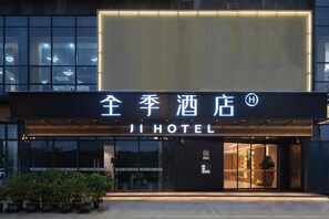 A hotel entrance with a modern facade, illuminated signage, and a visible entrance door. - Ji Hotel Guangzhou Huangpu Wenchong (Guangzhou)