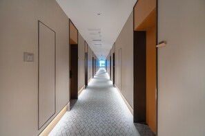 A long, narrow hallway with doors on both sides, leading to individual rooms. - Ji Hotel Guangzhou Huangpu Wenchong (Guangzhou)