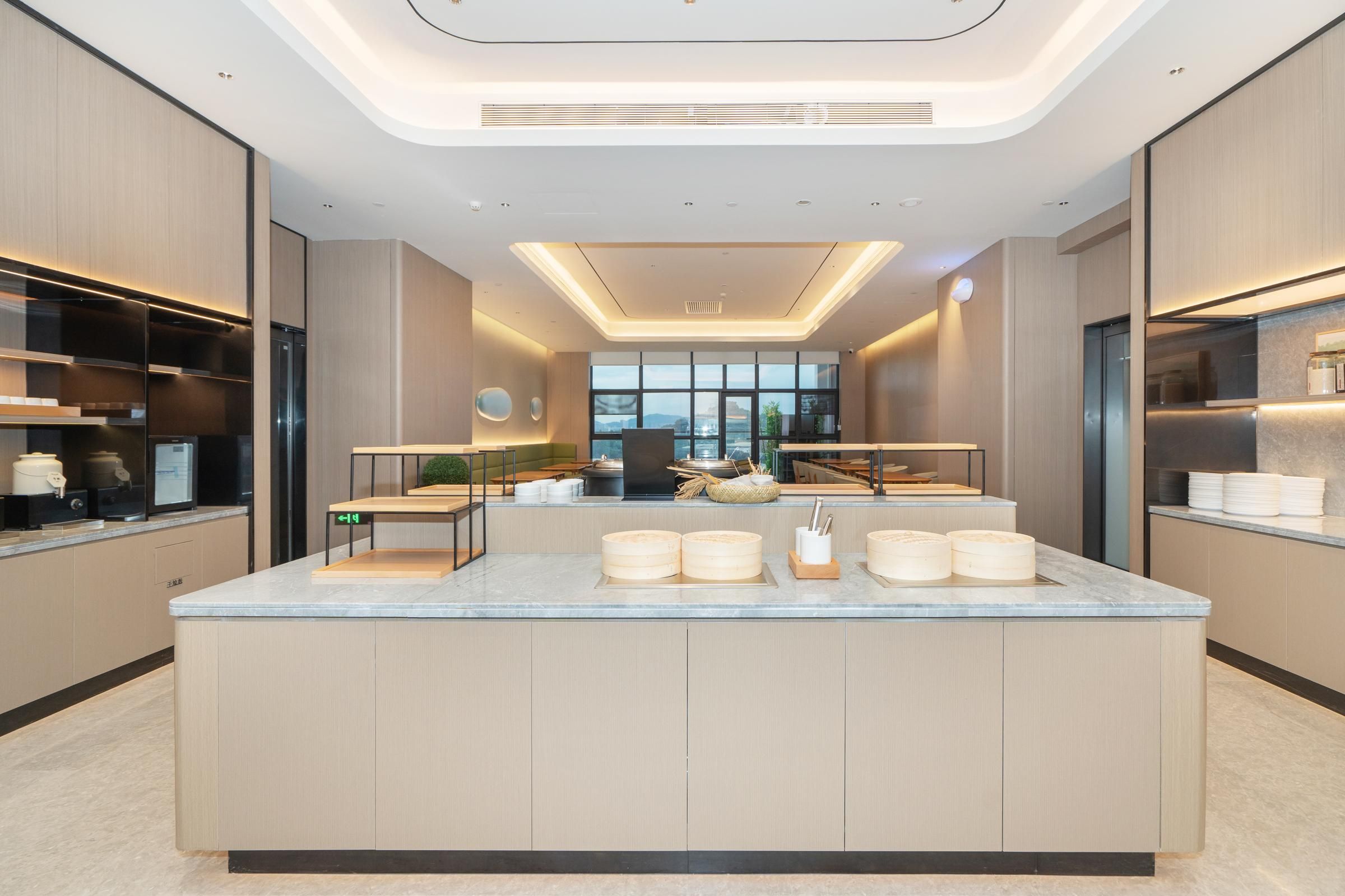 A modern kitchen with a central island, built-in appliances, and a view of the city.