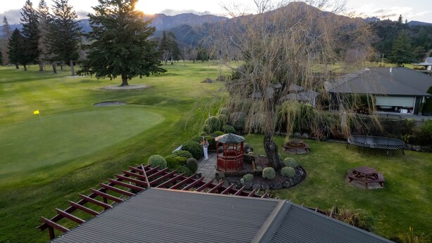 A golf course with a gazebo, picnic tables, and a view of mountains in the background. - Alpine Springs Motel | Unit 8 - HS61218 (Hanmer Springs)