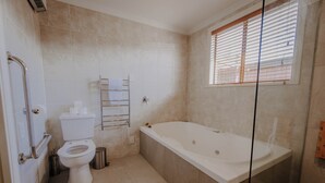 A modern bathroom with a toilet, bidet, and a glass-enclosed shower area. - Alpine Springs Motel | Unit 8 - HS61218 (Hanmer Springs)