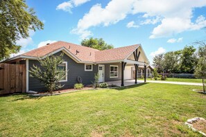 A single-story house with a covered porch, a fenced yard, and a clear sky. - 3BR Near Lackland AFB • Military & ALE Stays • W/D (San Antonio)