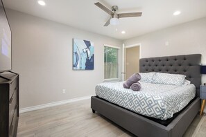 A bedroom with a bed, a ceiling fan, a painting, and a window with blinds. - 3BR Near Lackland AFB • Military & ALE Stays • W/D (San Antonio)