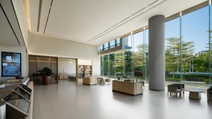 A spacious lobby with a large glass wall, a reception desk, seating area, and a tall column. - Ji Hotel Guangzhou Huangpu Science City Luogang (Guangzhou)