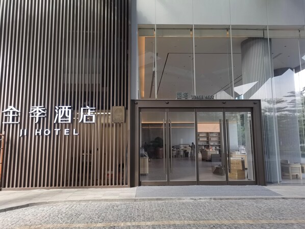 A hotel entrance with a modern design, featuring a vertical wooden panel and a glass door entrance. - Ji Hotel Guangzhou Huangpu Science City Luogang (Guangzhou)