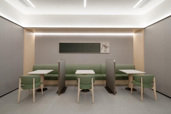 A modern, minimalist waiting area with green seating and white tables, featuring a neutral color palette and recessed lighting. - Ji Hotel Guangzhou Huangpu Science City Luogang (Guangzhou)