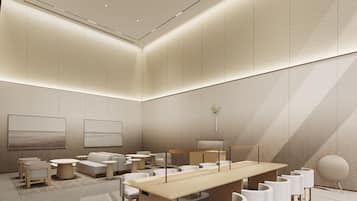 A modern conference room with a long table, multiple chairs, and a minimalist design.