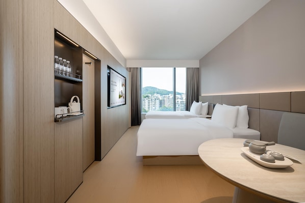 A modern hotel room with a large bed, a bedside table with a tray, a wardrobe with shelves, and a large window offering a city view. - Ji Hotel Guangzhou Huangpu Science City Luogang (Guangzhou)
