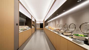 A modern, well-lit corridor with a long counter displaying various food items and containers.