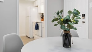A modern kitchen with white cabinets and a blue towel hanging on the oven door.