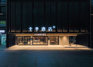 A hotel with a modern facade, illuminated signage, and a reception area visible through the glass doors. - Ji Hotel Guangzhou Huadu Square Metro Station (Guangzhou)