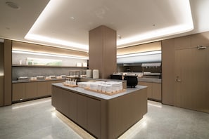 A modern kitchen with a central island, built-in appliances, and a sleek design. - Ji Hotel Guangzhou Huadu Square Metro Station (Guangzhou)