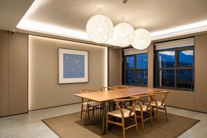 A modern conference room with a large wooden table, six chairs, and a large window with a city view. - Ji Hotel Guangzhou Huadu Square Metro Station (Guangzhou)