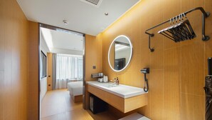 Une salle de bain moderne avec un meuble-lavabo en bois, un grand miroir et un porte-serviettes.