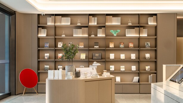 A modern reception area with a central desk, a bookshelf with awards, and a red chair. - Ji Hotel Guangzhou Huadu Square Metro Station (Guangzhou)